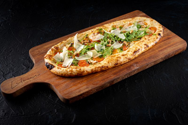 Pizza con jamón serrano, rúcula y parmesano